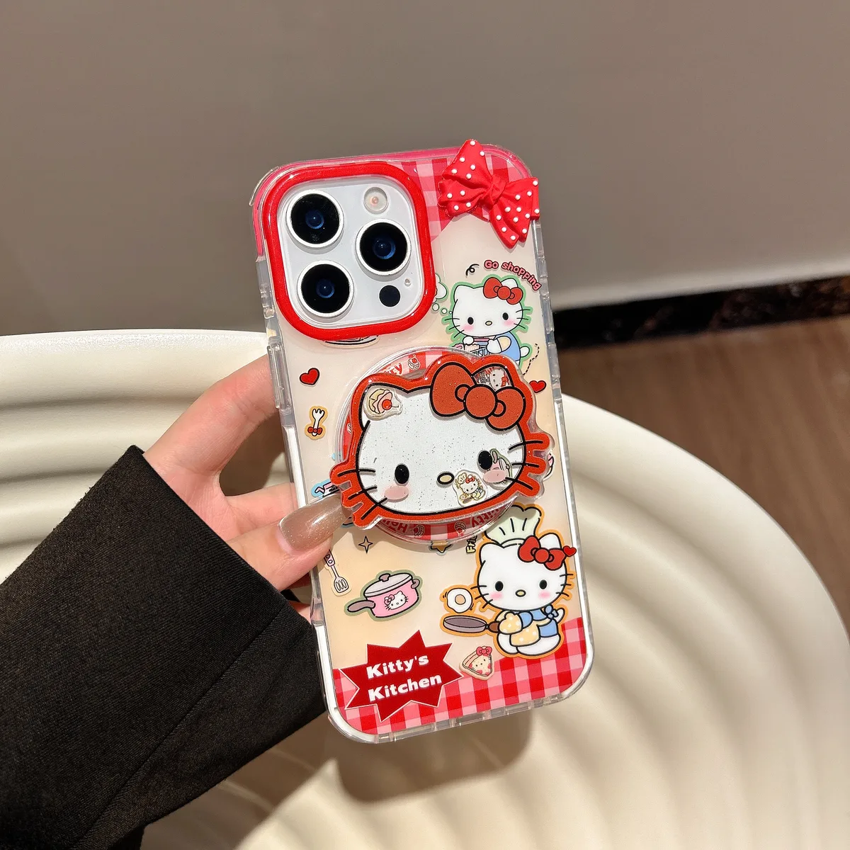 Clear Hello Kitty phone case with red gingham, 3D bow, and kitchen-themed Sanrio graphics
