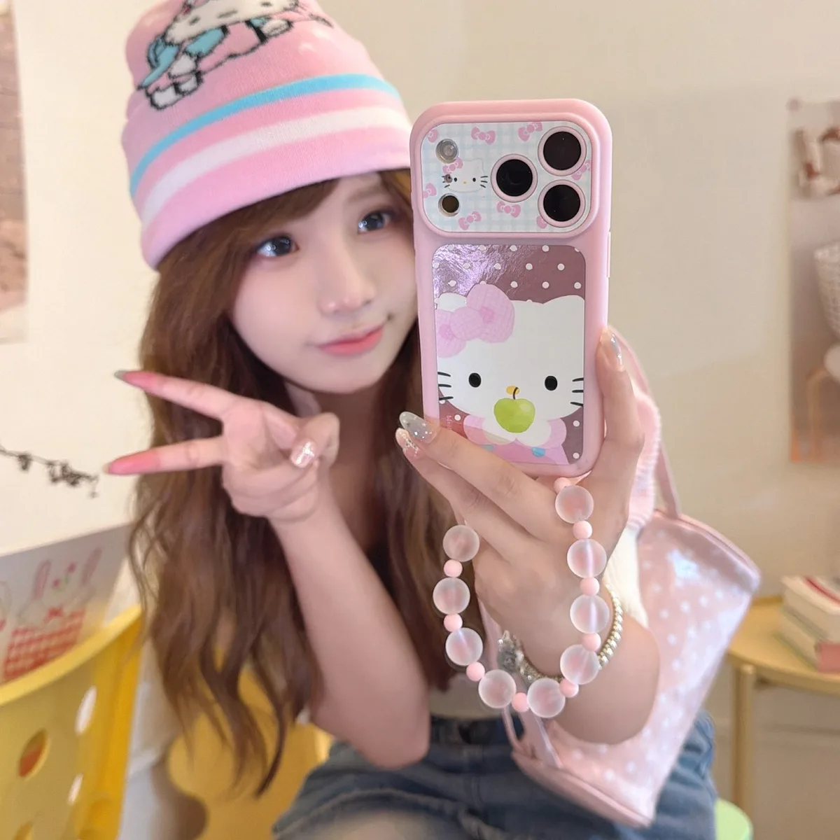 Pink Hello Kitty phone case with bow print and a frosted beaded wrist strap