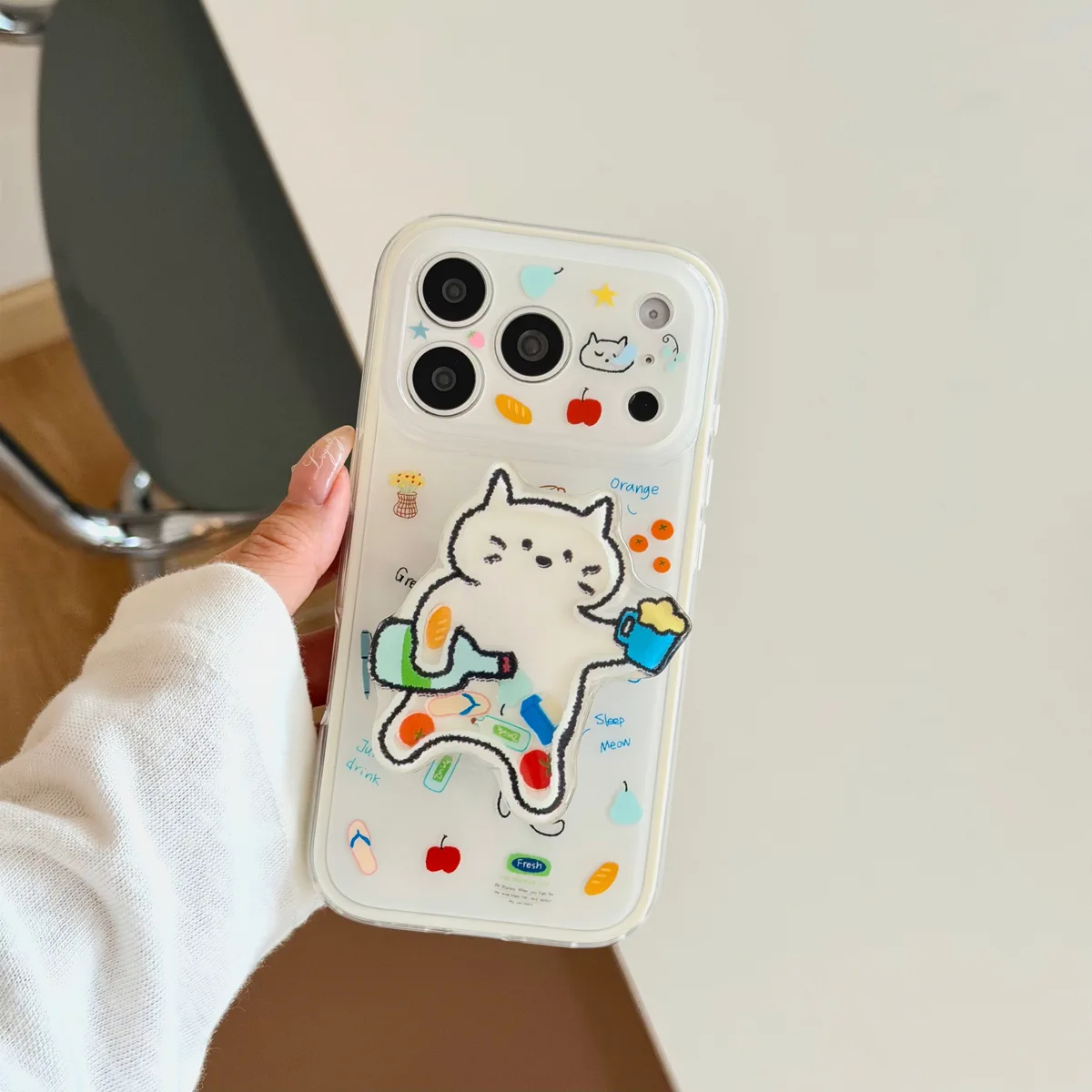 Clear phone case with a cartoon cat grip and colorful doodle decorations
