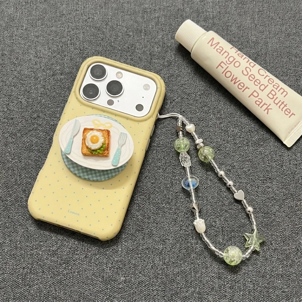 Yellow phone case with a 3D toast and egg plate decoration and a beaded strap