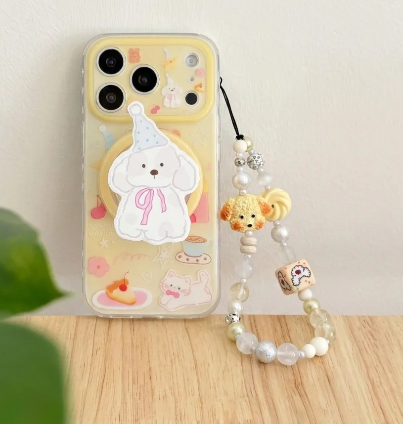 Clear phone case with a pastel puppy graphic, yellow background art, and a beaded wrist strap