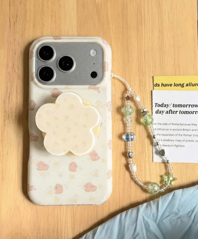 Cream phone case with tiny bunny prints and a flower-shaped grip accessory