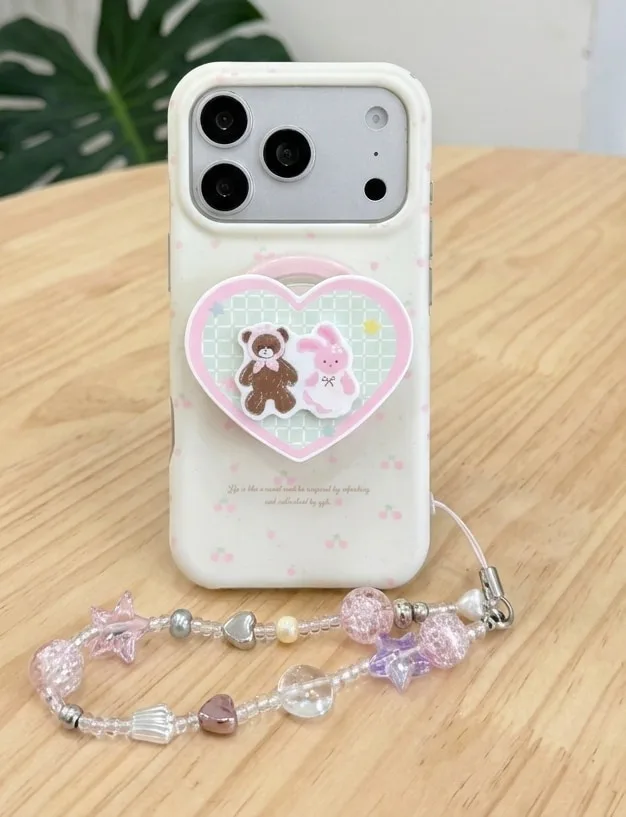 Pastel white phone case with a heart charm, teddy bear and bunny design, plus a beaded strap