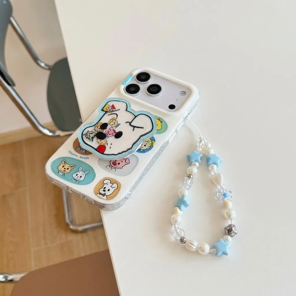 Clear phone case with a cartoon dog face charm and pastel character stickers, shown with a beaded strap.