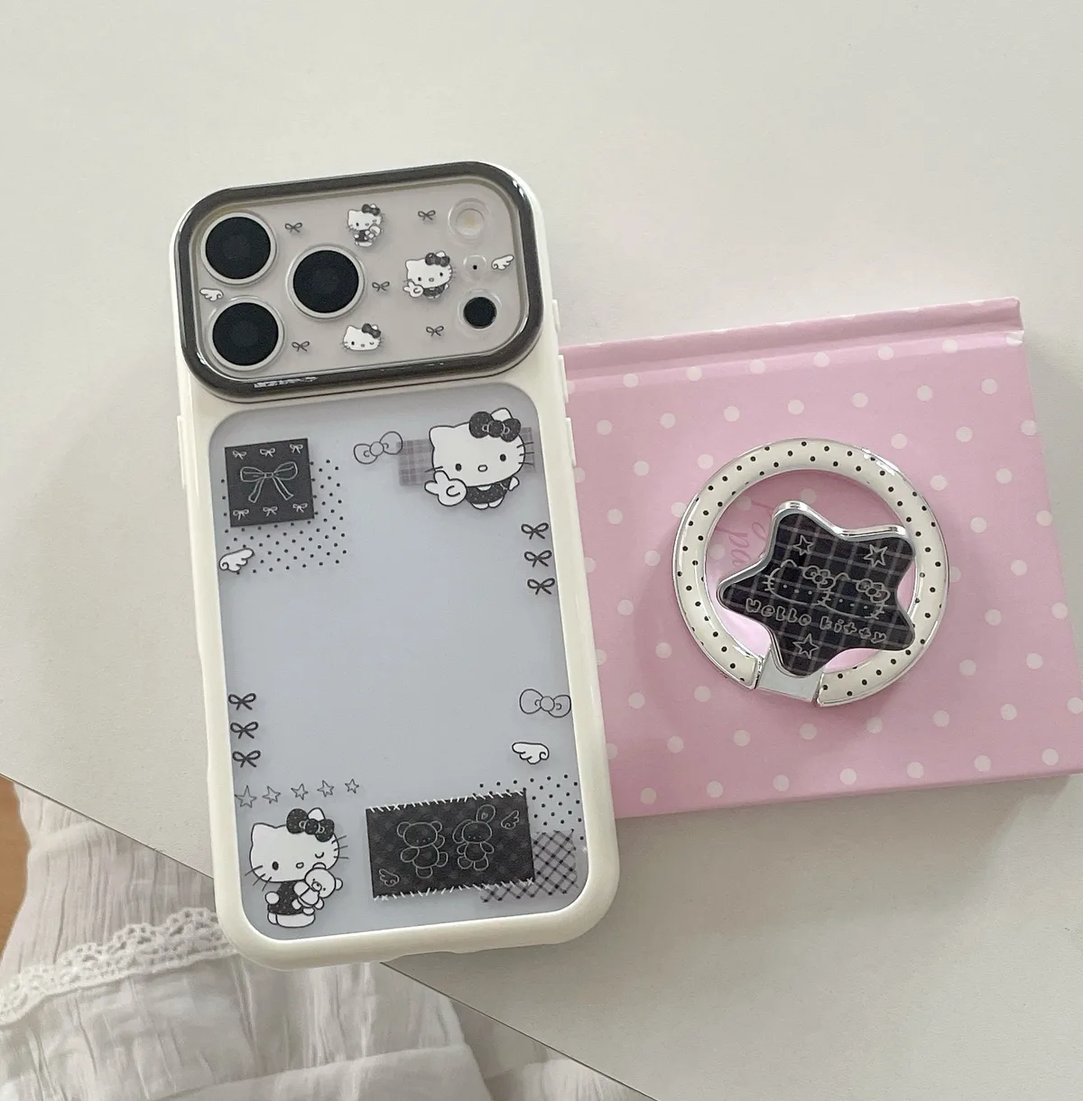 Hello Kitty phone case with black and white patchwork art and a matching ring grip accessory